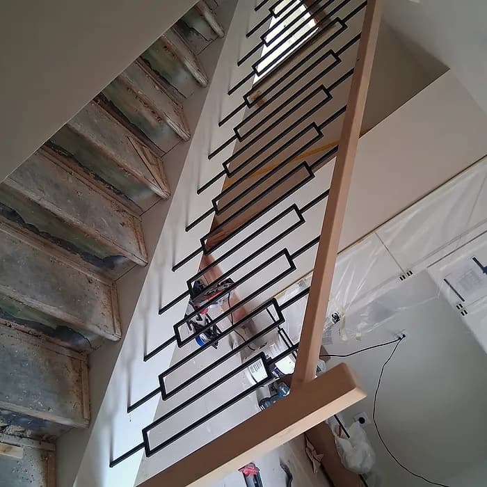 Open staircase with a custom iron-baluster railing
