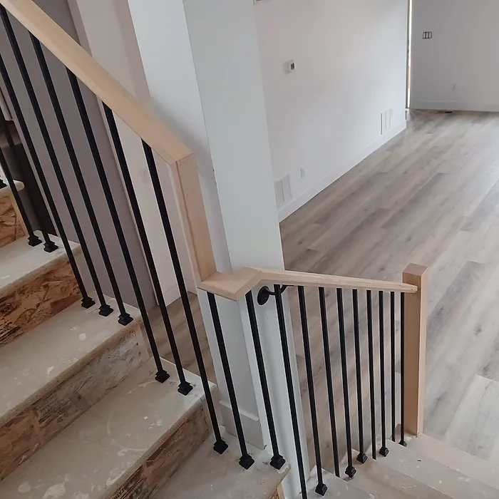 Staircase with iron balusters and reclaimed-wood risers